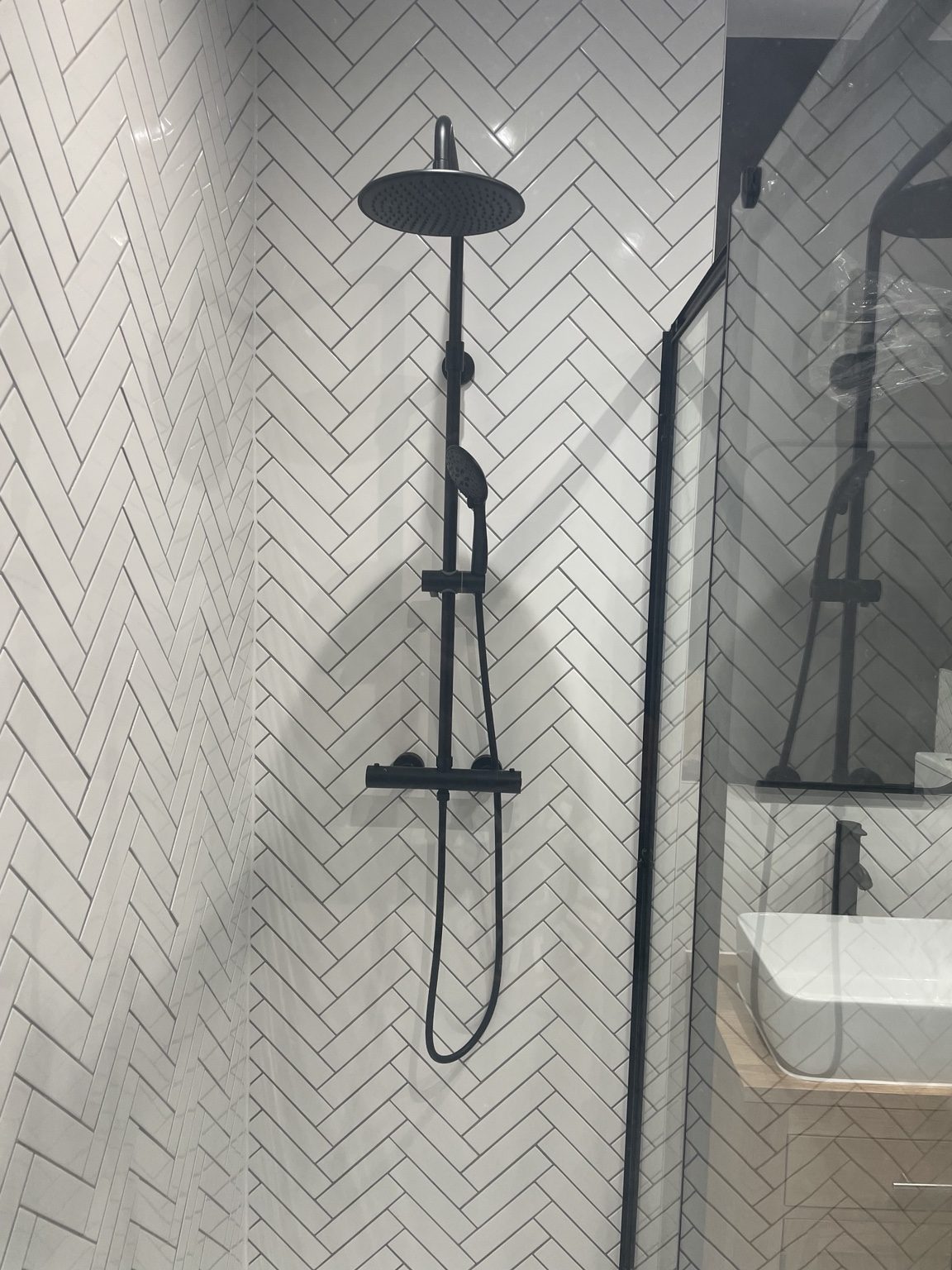 Completed bathroom with a walk-in shower, dark green tiles and vanity unit